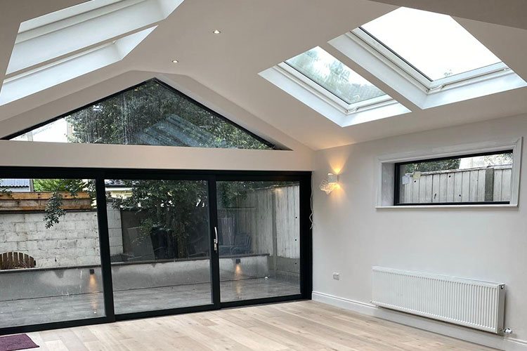 A rear extension with a fully glazed gable and sliding doors onto a patio
