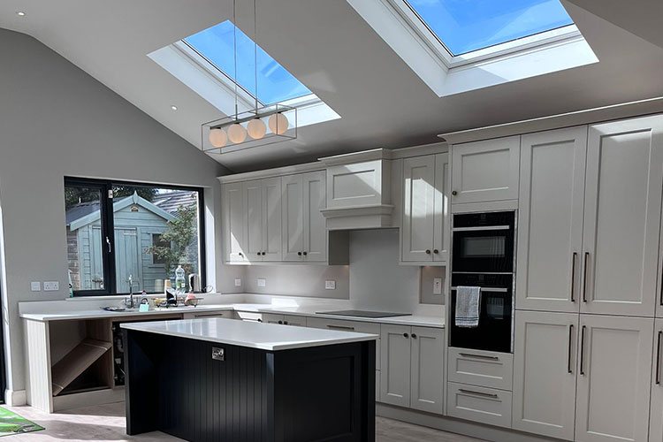 A finished kitchen extension with rooflights, an island and glazed doors onto the garden